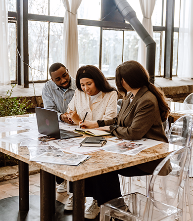 Couple meeting with wedding coordinator to plan event details at a modern venue.