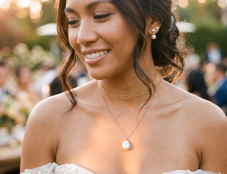 Filipino bride in strapless ivory gown wearing layered gold filigree choker and rose gold baroque pearl pendant necklace, golden hour light on neckline, editorial wedding photography