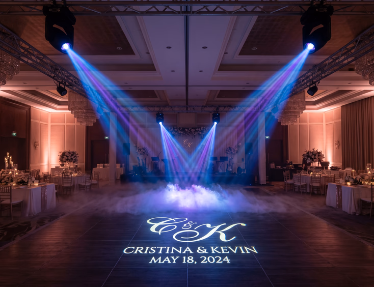 Empty Filipino wedding reception dance floor with moving head light beams, rose gold uplighting, gobo monogram, and low-lying fog