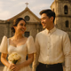 Young Filipino couple outside a historic church the bride in a modern Filipiniana gown with subtle butterfly sleeves the groom in a barong warm afternoon light