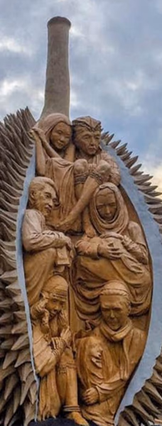 A wooden sculpture carved inside a durian fruit, featuring religious figures