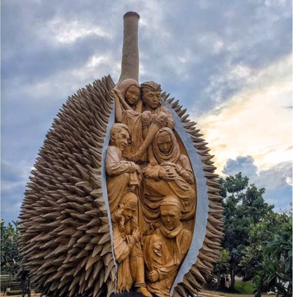 A wooden sculpture carved inside a durian fruit, featuring religious figures