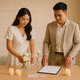 Young Filipino couple styling a simple signing table with bouquet bud vases and LED candles